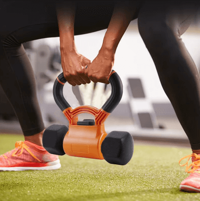 Kettlebell orange pour entraînement de force, utilisé par une personne sur un tapis de gym.