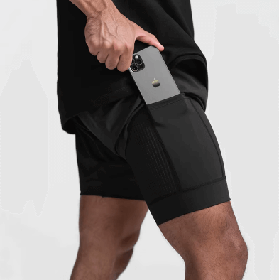 Homme portant un short de course noir, intégrant une poche pour téléphone, alliant confort et performance.