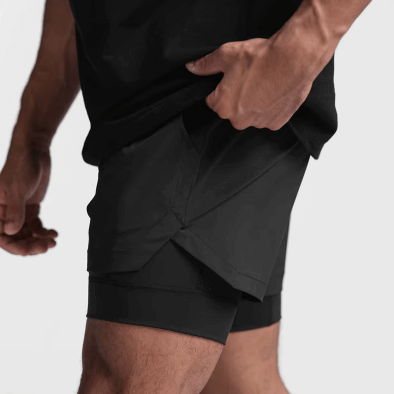 Homme ajustant son short de course noir, offrant liberté, confort et performance pour le jogging et les entraînements.